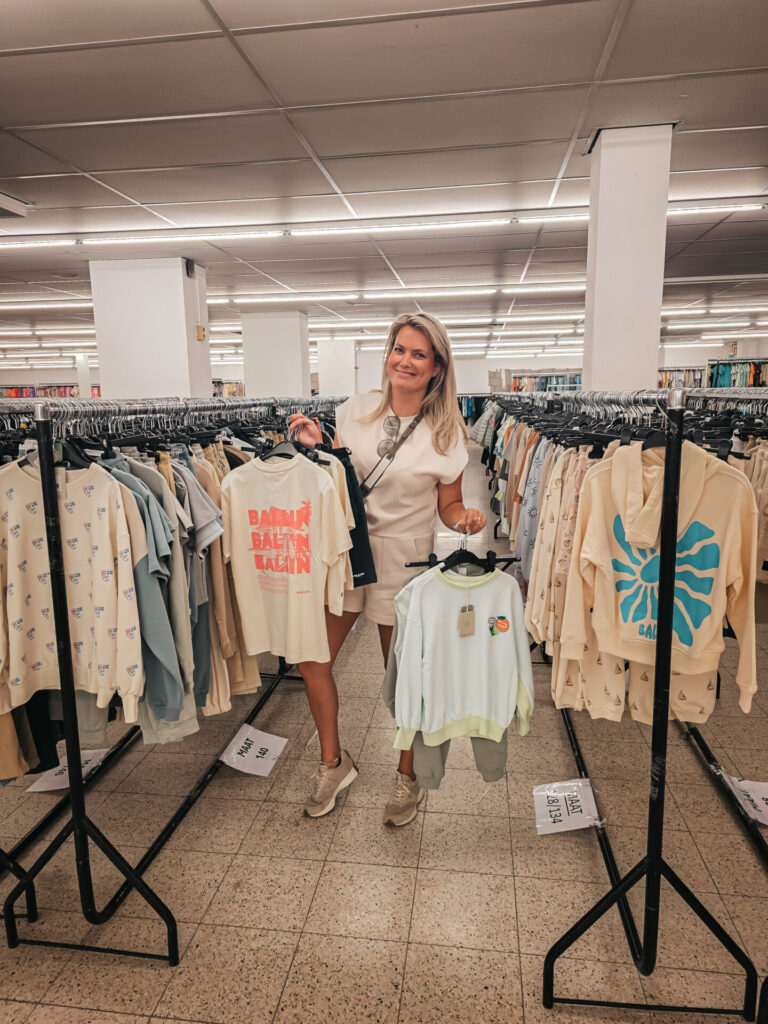Vrouw bekijkt kleding in een ruime winkel