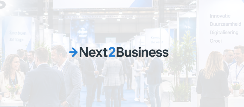 Next2Business-logo boven netwerkende bezoekers op beursvloer