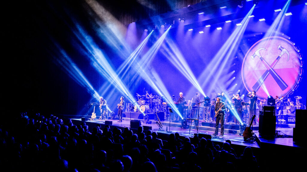 Liveband en orkest onder blauwe podiumverlichting