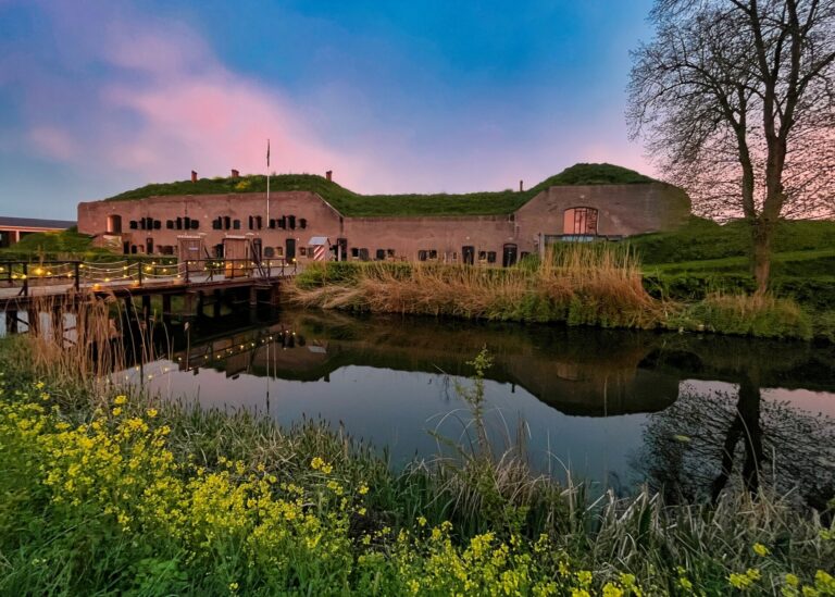 Historisch fort weerspiegeld in water bij zonsondergang