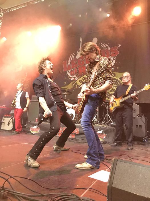 Rockband treedt energiek op op verlicht podium