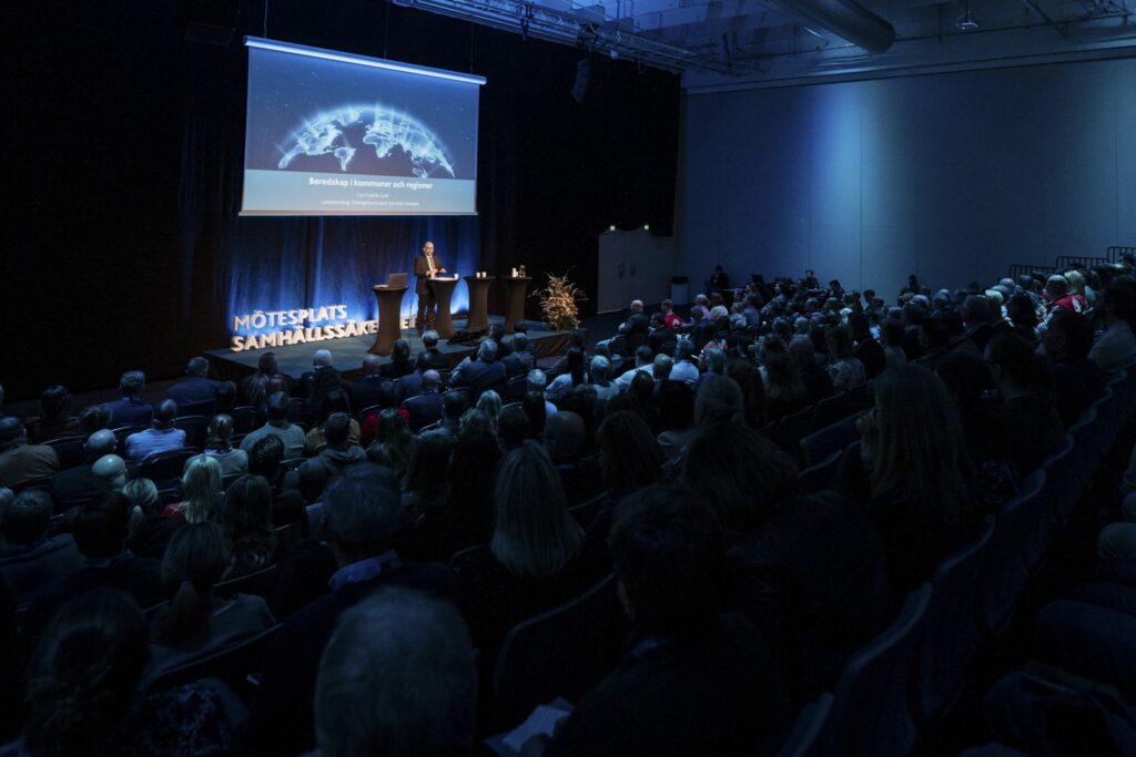 Fullsatt konferens med talare på scen
