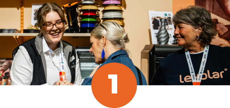 Glad utställare pratar med besökare