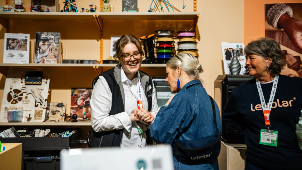 Utställare pratar med besökare i monter