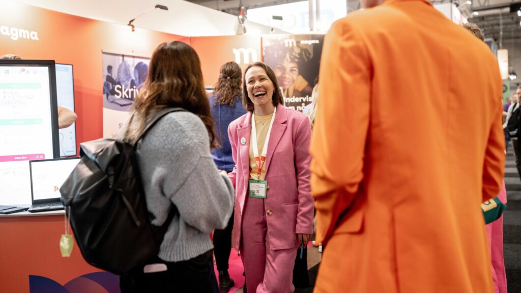 Glad utställare pratar med besökare