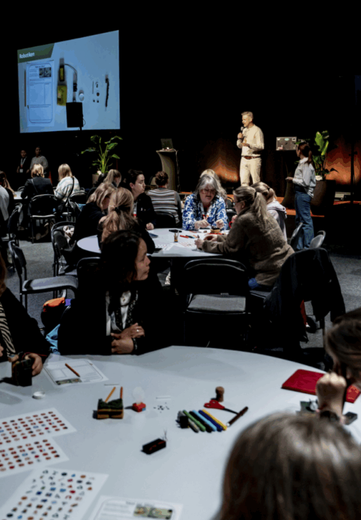 Besökare under en konferens som sitter vid runda bord