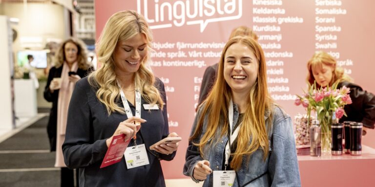 Två glada tjejer på mässgolvet