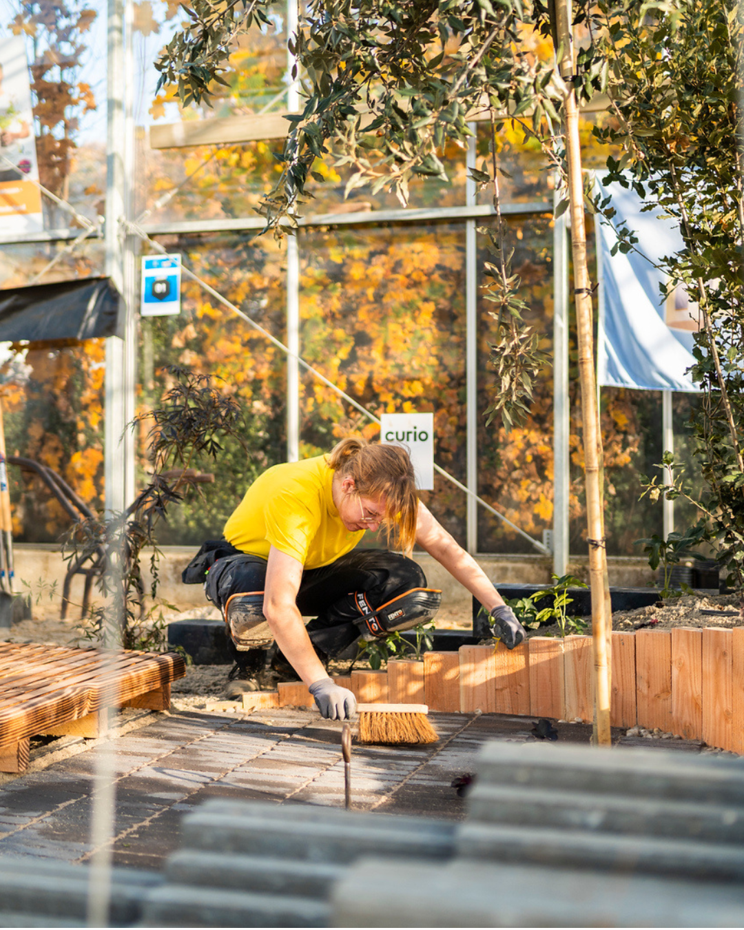 Hovenier legt bestrating aan in een groene stadstuin