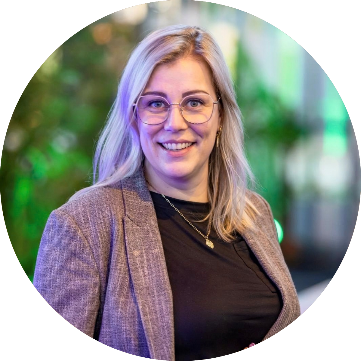 Glimlachende vrouw met bril in een blazer