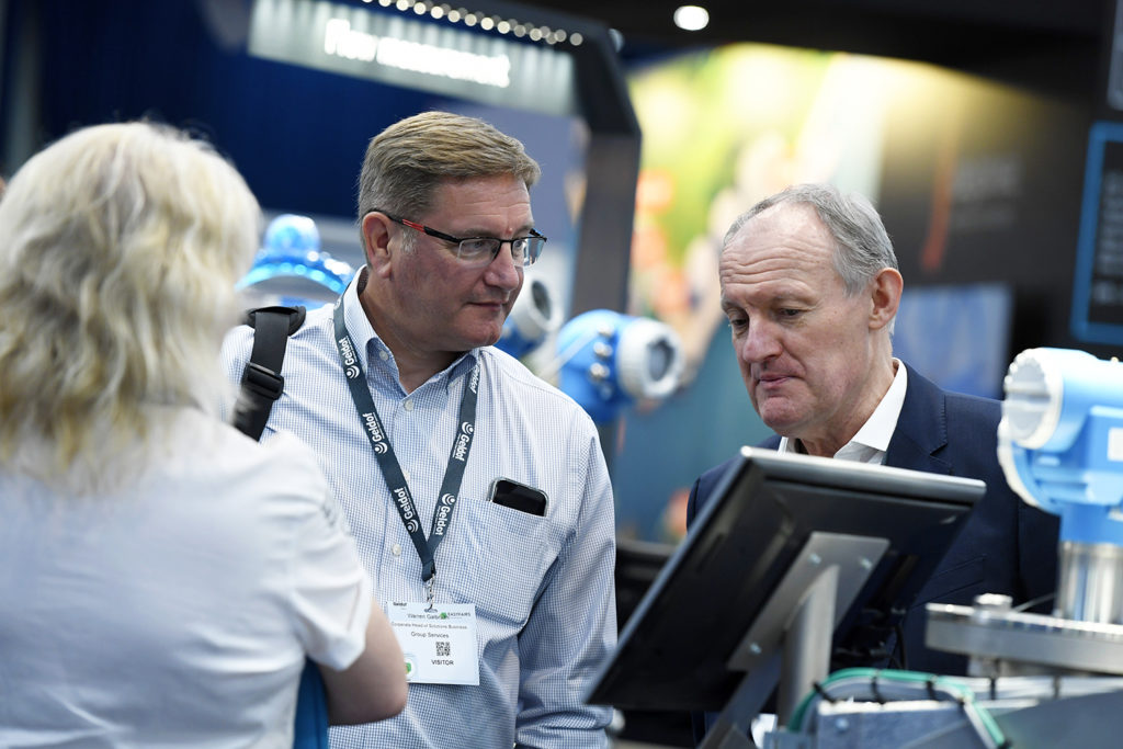 three people chatting and networking at stocexpo