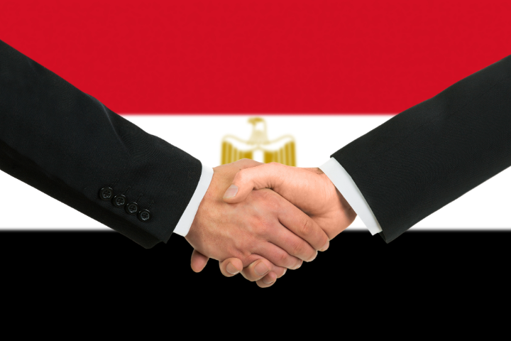shaking hands in front of Egypt flag