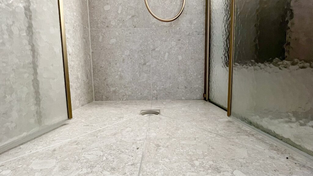 Badkamerrenovatie met ceppo di gre en bronzen kranen