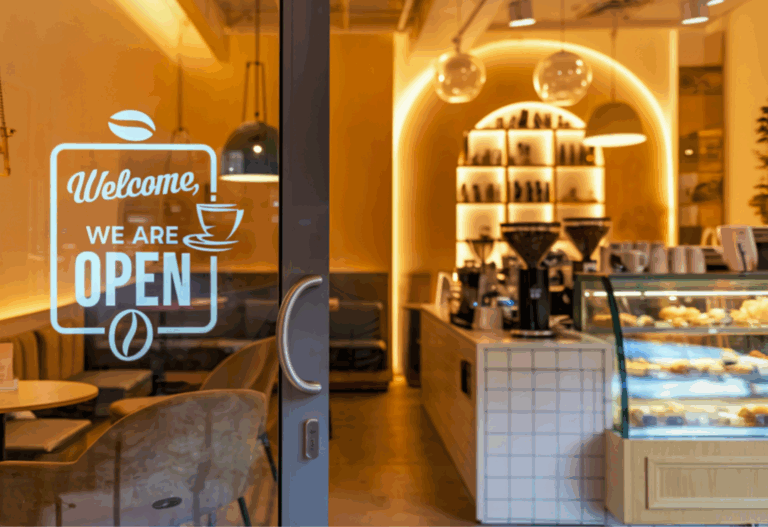 Open coffeeshop met verlichte toonbank en gebaksvitrine