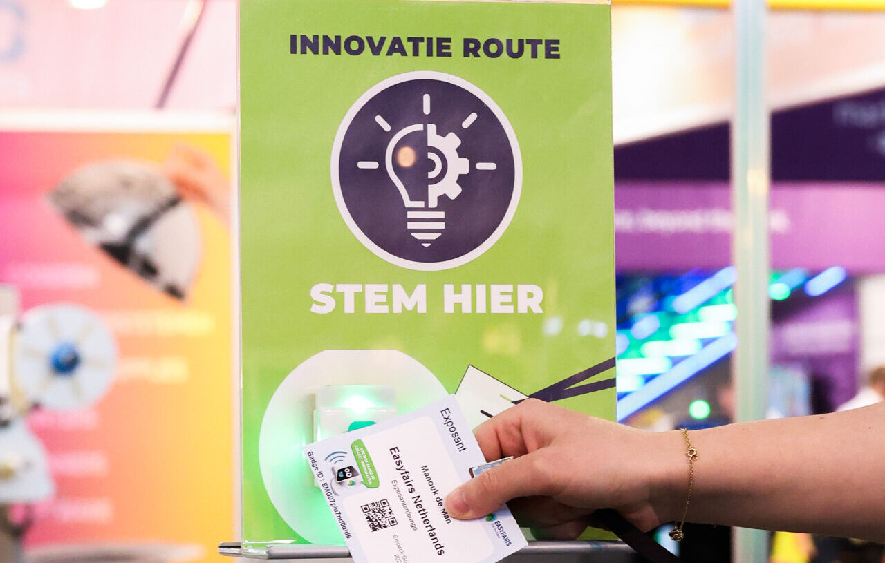 Bezoeker scant badge bij bord Innovatie Route