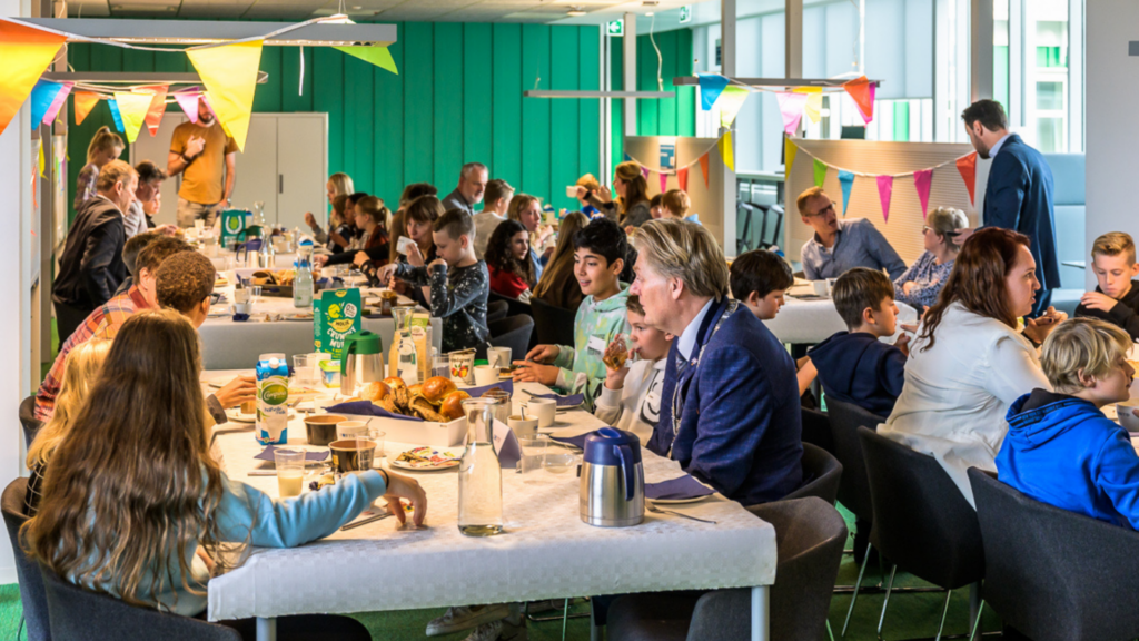 Mensen genieten van een feestelijke gezamenlijke maaltijd binnen.
