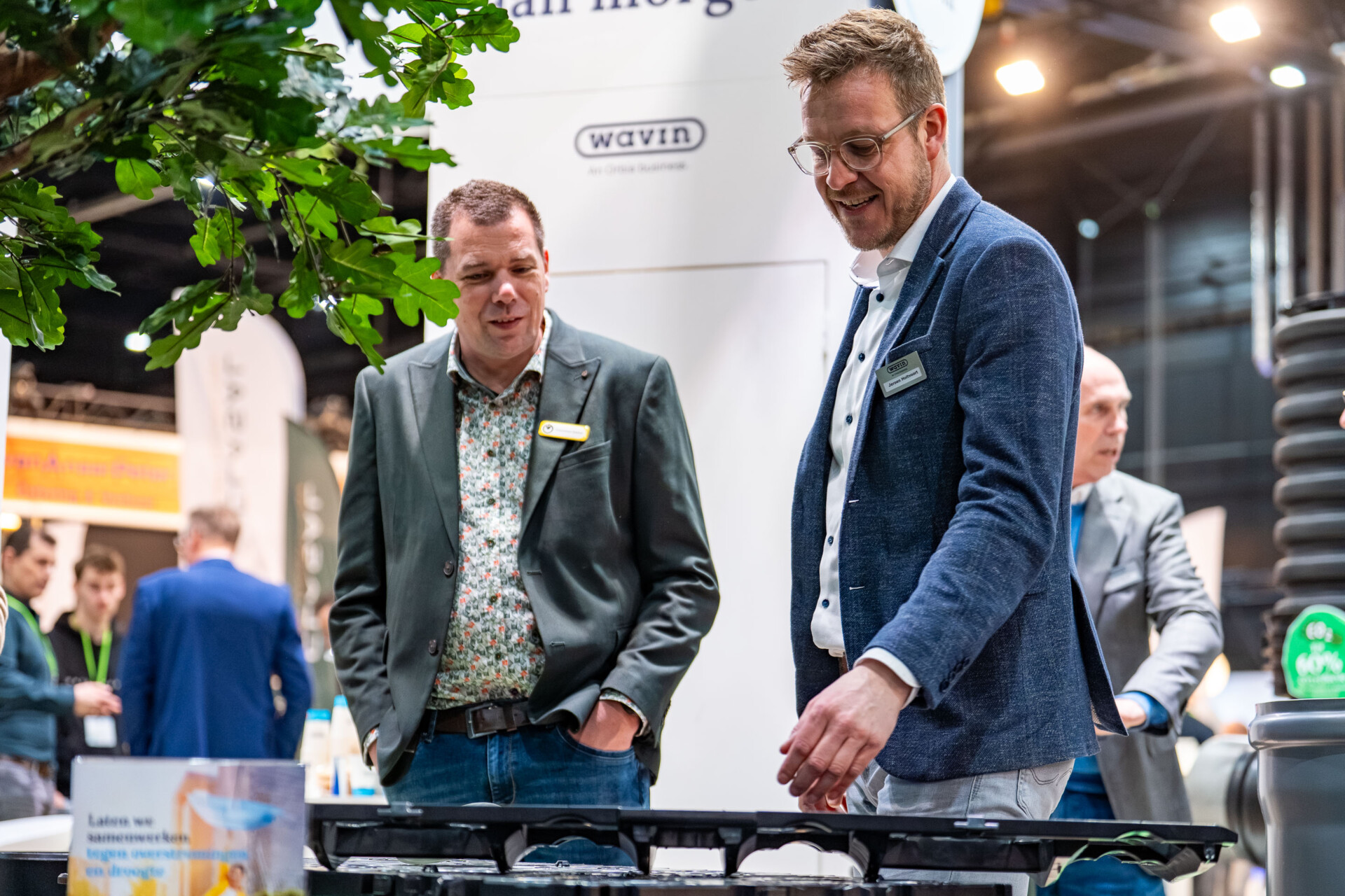 Twee mannen bekijken product op Wavin-beursstand