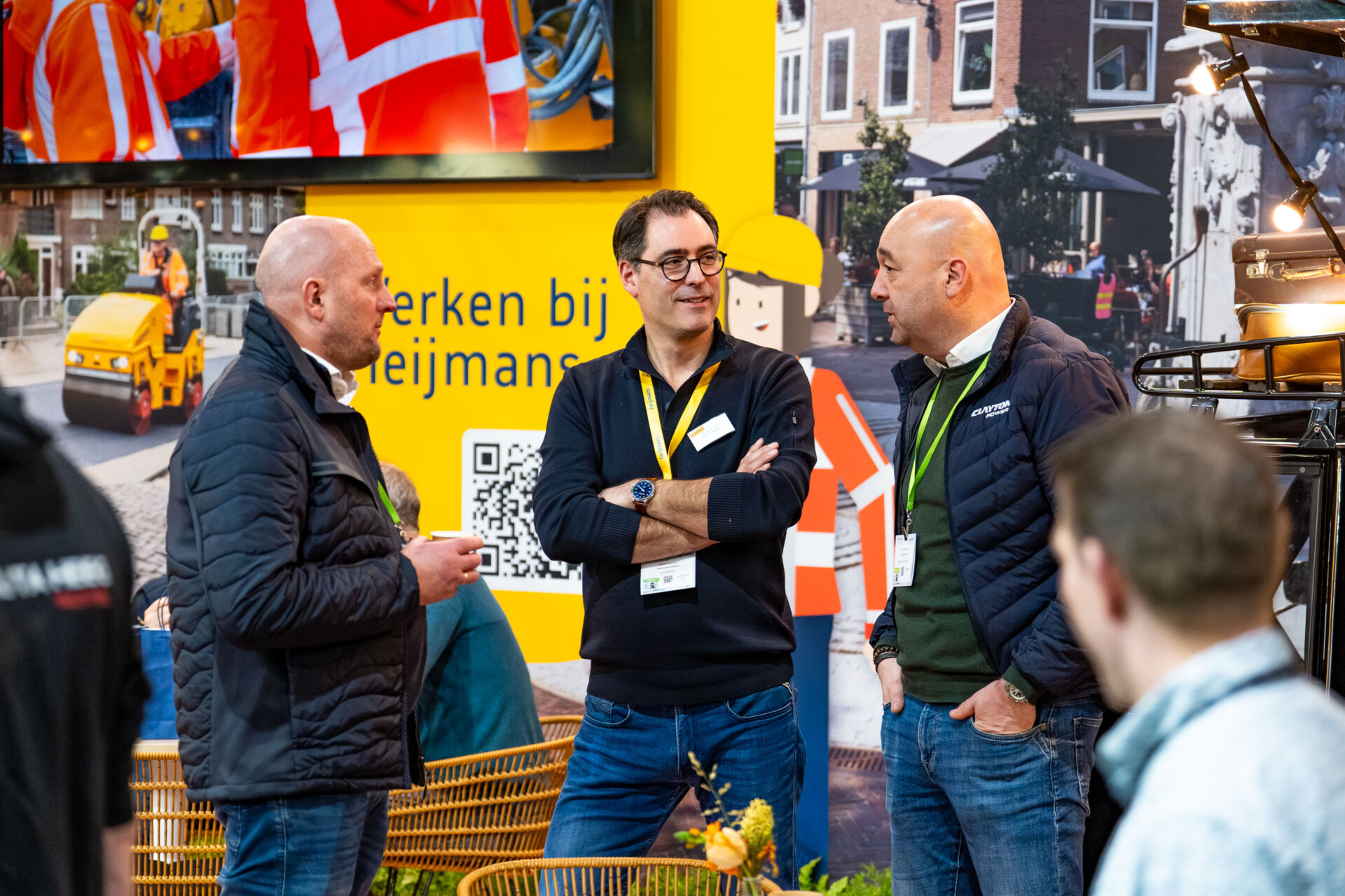 Drie mannen in gesprek op stand van Heijmans