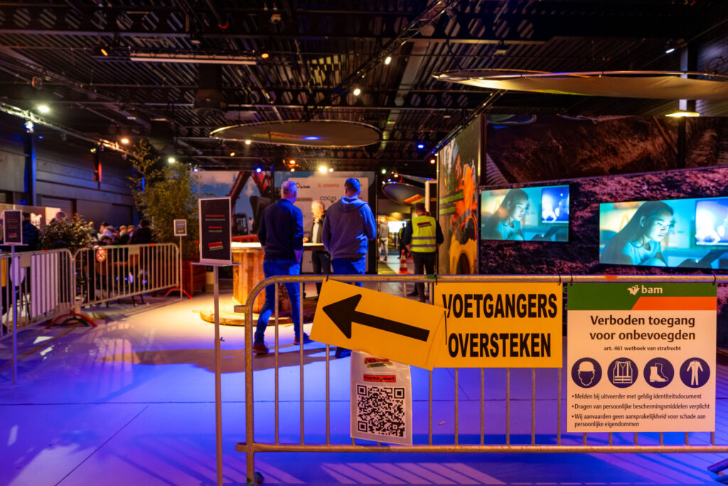 Bezoekers bij afgezette ingang van industriële evenementlocatie