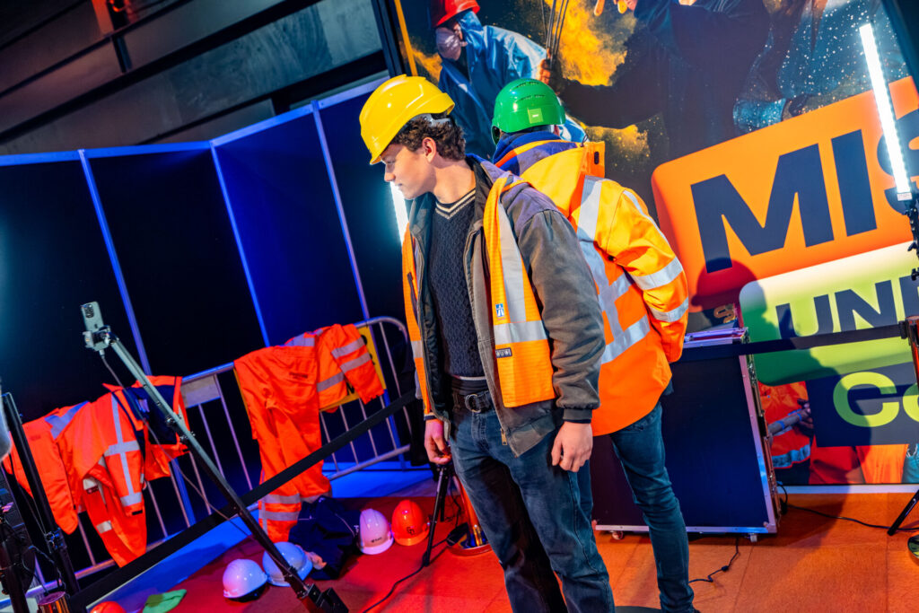 Bezoekers passen veiligheidshelmen en reflecterende werkvesten