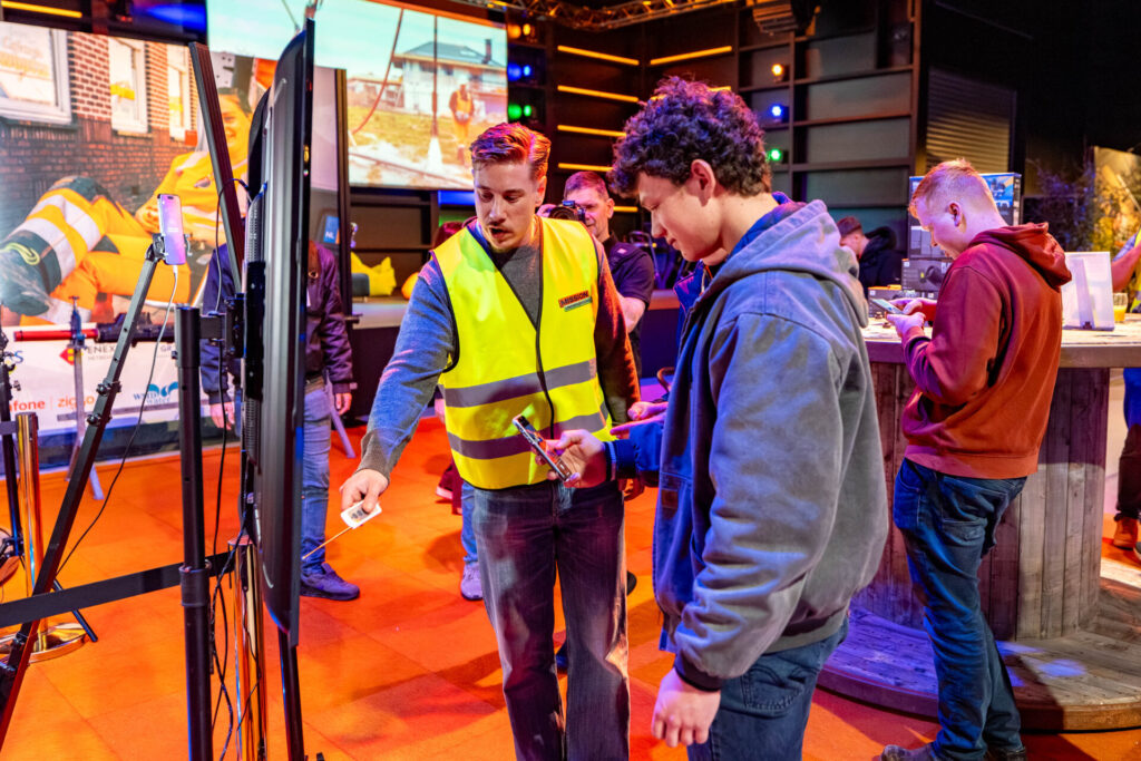Begeleider demonstreert technologie aan bezoekers op evenement