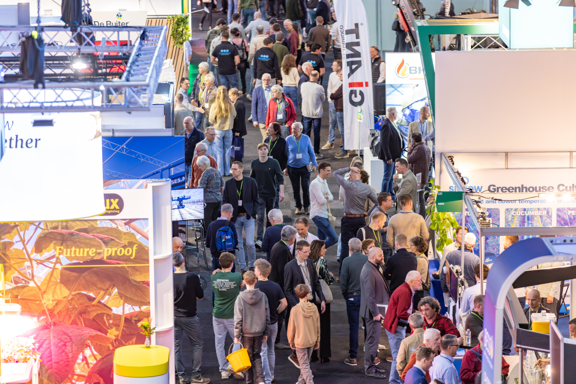 Drukke bezoekersstroom op vakbeurs tussen stands