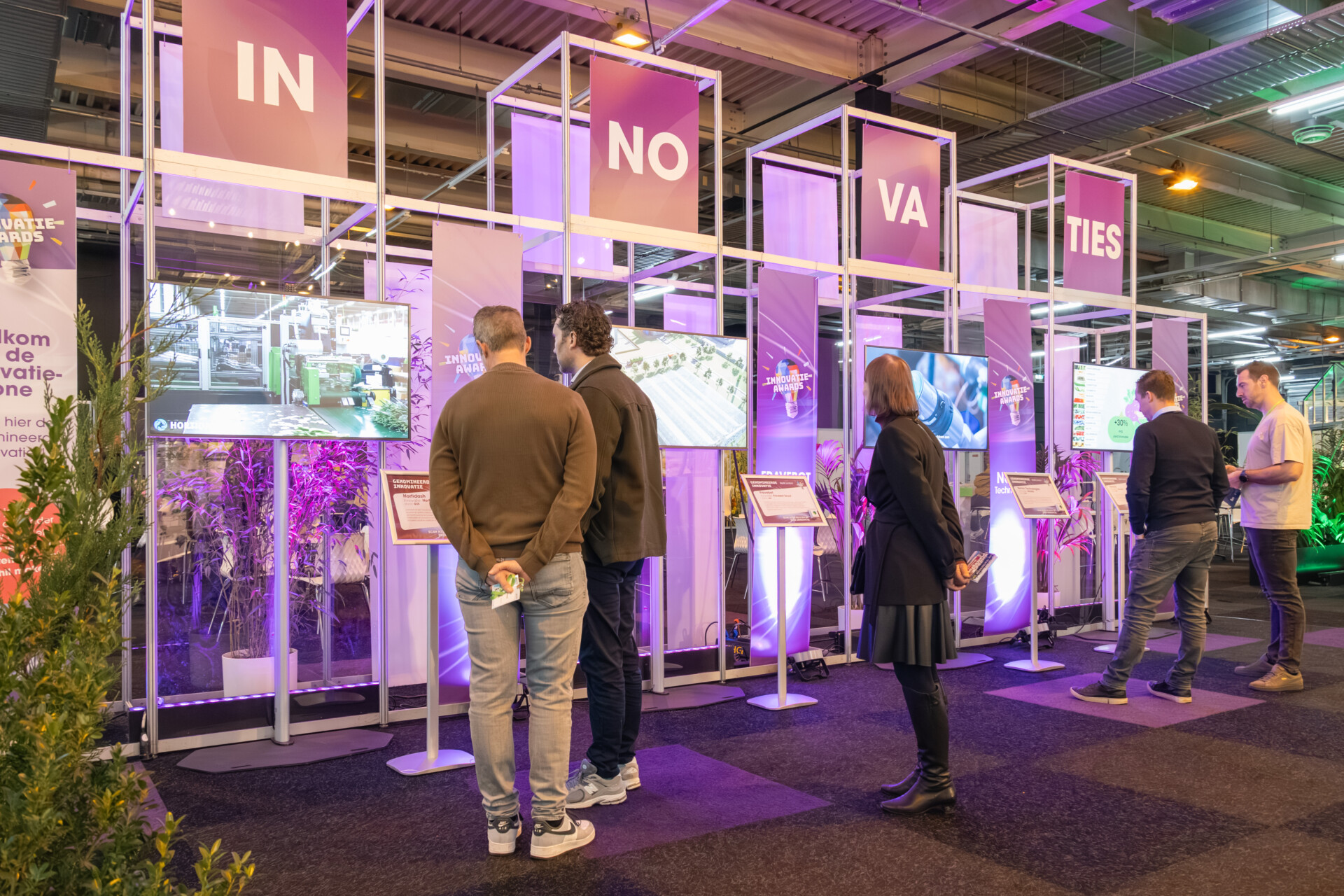 Bezoekers bekijken innovatietechnologie op beursstand