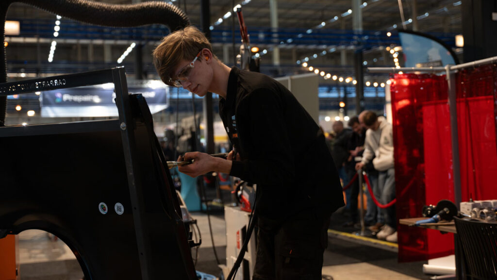 Monteur werkt aan voertuig op vakbeurs