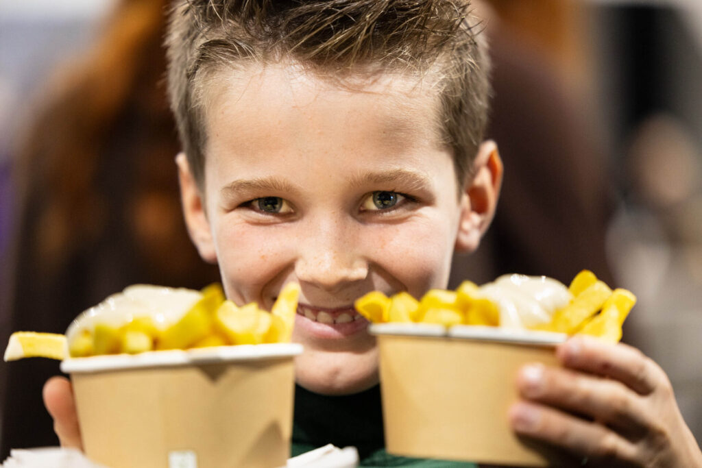 Jongen met twee bekers friet en mayonaise