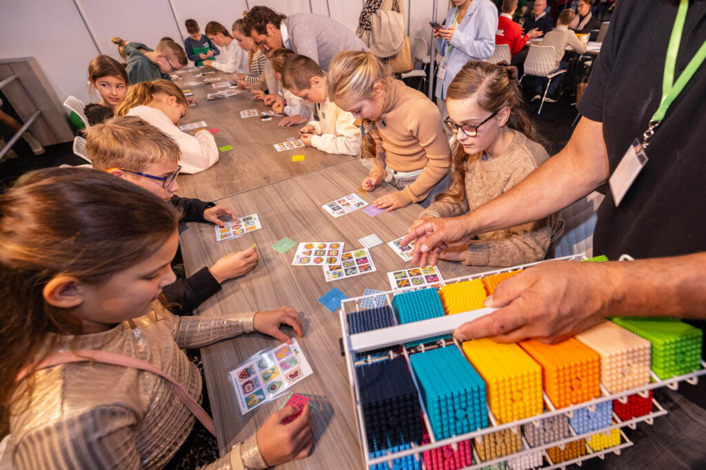 Kinderen maken pixelkunst met kleurrijke blokjes aan tafel