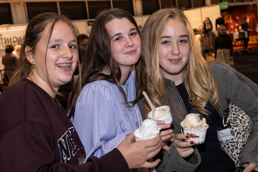 Drie meisjes eten ijs op een evenement