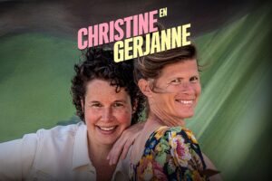 Christine en Gerjanne glimlachend voor groene achtergrond