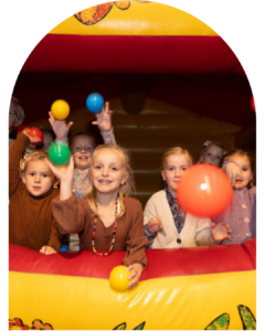 Kinderen spelen met gekleurde ballen in springkussen