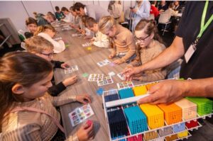 Kinderen bouwen met kleurrijke bouwblokjes aan lange tafel
