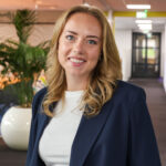 Glimlachende vrouw in blauw colbert op kantoor