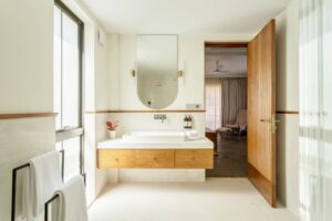 Afbeelding van een moderne, witte badkamer met houtelementen.