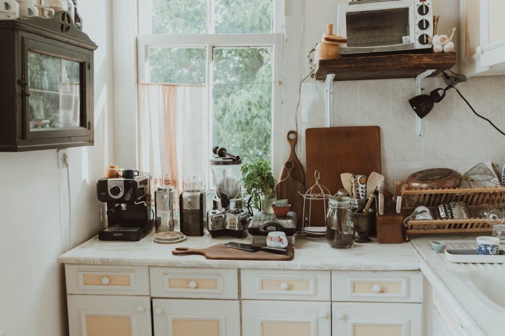 Afbeelding van een ouderwetse en ongeorganiseerde keuken met een vol aanrecht.