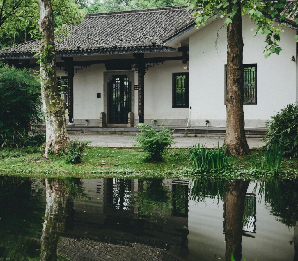 Afbeelding van een huis met een voortuin die ondergelopen is met water.