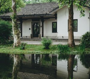 Afbeelding van een huis met een voortuin die ondergelopen is met water.