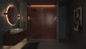 Een moderne badkamer met kleine, glanzende bordeaux wandtegels met subtiel reli&euml;f, gecombineerd met een donkerhouten zwevende wastafel, zwarte matte kranen en een ruime inloopdouche met glazen wand. De warme verlichting en mid-century modern details geven de ruimte een stijlvolle, intieme sfeer.