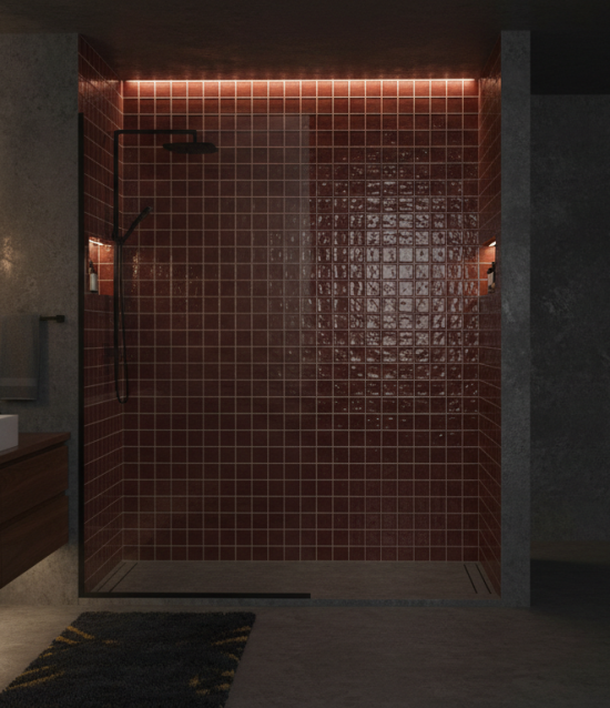 Een moderne badkamer met kleine, glanzende bordeaux wandtegels met subtiel reliëf, gecombineerd met een donkerhouten zwevende wastafel, zwarte matte kranen en een ruime inloopdouche met glazen wand. De warme verlichting en mid-century modern details geven de ruimte een stijlvolle, intieme sfeer.