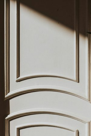 Foto van een witte deur mer sierlijsten.
