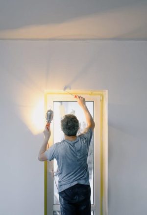 Foto van een man die een deur aan het herstellen is.