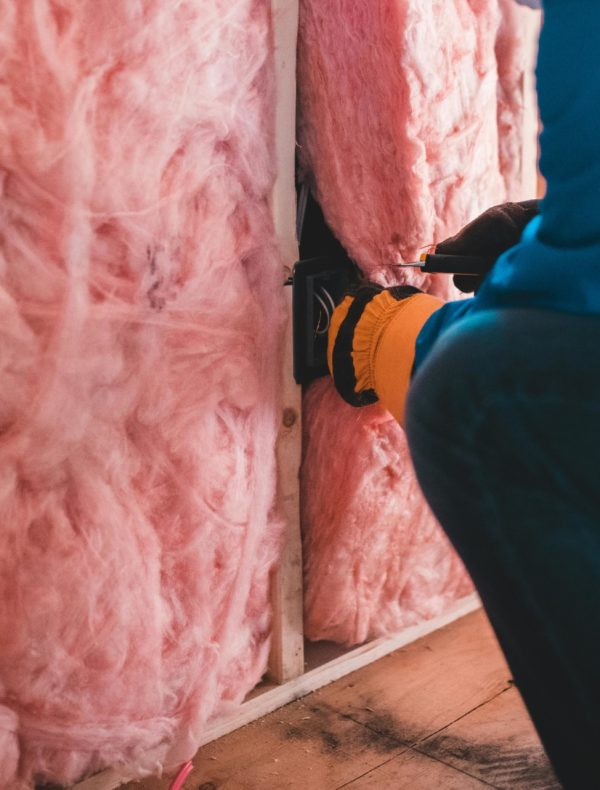 Energieneutrale woning pexels-Erik Mclean Roze isolatiemateriaal dat in een muur bevestigd wordt.