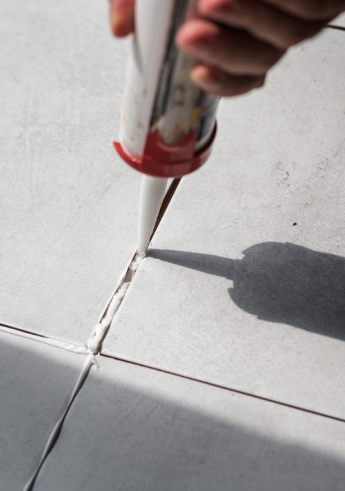 Voegen van vloertegels die opnieuw afgekit worden.