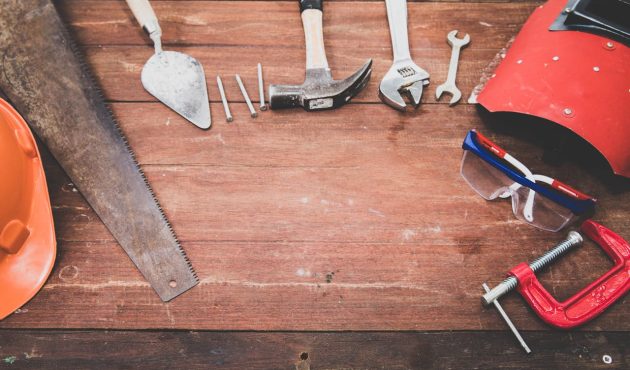 Foto van gereedschap: een hamer, een moersleutel, een zaag, spijkers, enzovoort.