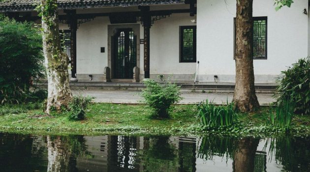 Afbeelding van een huis met een voortuin die ondergelopen is met water.