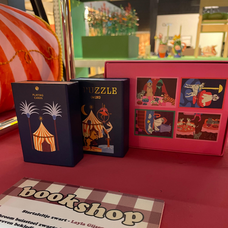 Speelkaarten, puzzel en boekshop-magazine met circusillustraties
