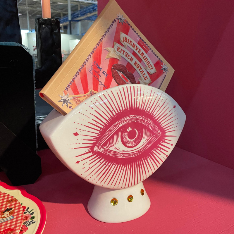Witte ooglamp met rood stralenmotief en vintage boek