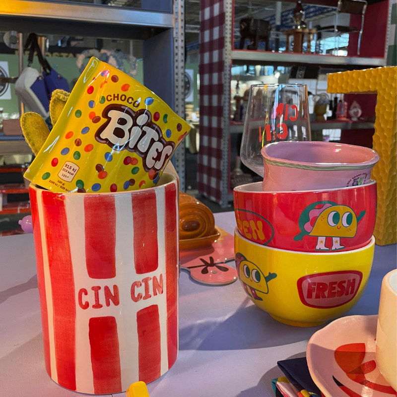 Kleurrijk servies met snackverpakking en gestreepte popcornbeker