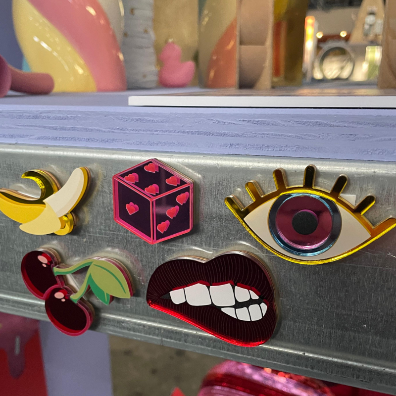 Vijf kleurrijke pins op een metalen plank